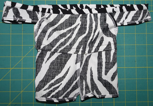 11. Pull shorts out so that everything is inside out and fold under the ¼” (6mm) raw edge that you pressed earlier.  Pin in place.  This will be the casing for the waist elastic.